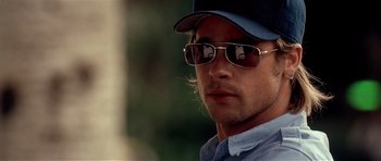 Movie still from “Spy Game” (2001), directed by Tony Scott – A person wearing sunglasses and a hat; Close Up shot, Over the shoulder angle
