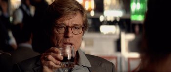 Movie still from “Spy Game” (2001), directed by Tony Scott – A person holding a glass of wine; Close Up shot, Over the shoulder angle