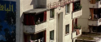 Movie still from “Spy Game” (2001), directed by Tony Scott – A man sitting on a balcony looking out of a window; Extreme Wide shot, High angle