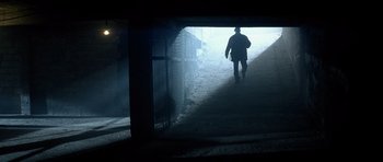 Movie still from “Spy Game” (2001), directed by Tony Scott – A man walking down a sidewalk in the dark; Wide shot, Low angle
