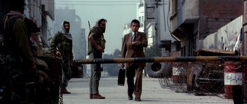 Movie still from “Spy Game” (2001), directed by Tony Scott – A man in a suit and tie standing next to another man in a suit and tie; Wide shot, Low angle