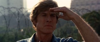 Movie still from “Spy Game” (2001), directed by Tony Scott – A person saluting with one hand; Close Up shot, Low angle