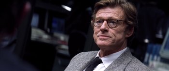 Movie still from “Spy Game” (2001), directed by Tony Scott – A person wearing a suit and tie; Close Up shot, Over the shoulder angle