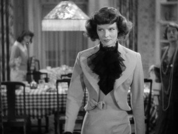 Movie still from “Stage Door” (1937), directed by Gregory La Cava – A black and white photo of a woman in a suit; Medium shot, Over the shoulder angle