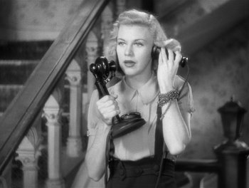 Movie still from “Stage Door” (1937), directed by Gregory La Cava – A black and white photo of a woman holding two phones; Close Up shot, Low angle