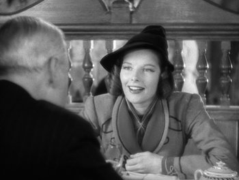 Movie still from “Stage Door” (1937), directed by Gregory La Cava – An old photo of a woman sitting at a table talking to a man; Medium shot, Over the shoulder angle