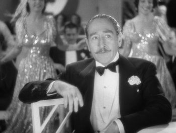 Movie still from “Stage Door” (1937), directed by Gregory La Cava – An older man sitting in a chair in front of a group of women; Close Up shot, Low angle