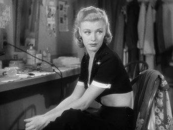 Movie still from “Stage Door” (1937), directed by Gregory La Cava – A black and white photo of a woman sitting at a desk; Medium shot, Low angle