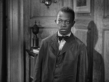 Movie still from “Stage Door” (1937), directed by Gregory La Cava – A black and white photo of a man in a suit; Medium shot, High angle