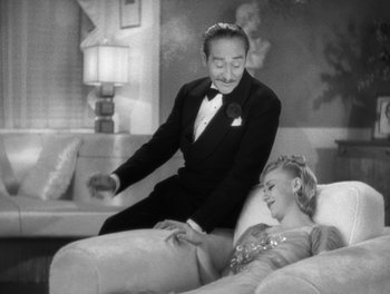 Movie still from “Stage Door” (1937), directed by Gregory La Cava – A man and a woman sitting on a white couch; Medium shot, High angle