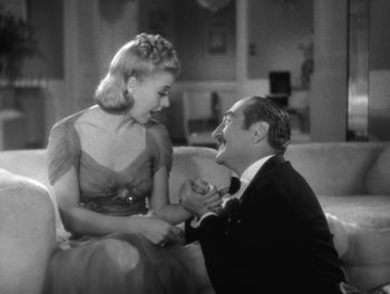 Movie still from “Stage Door” (1937), directed by Gregory La Cava – A man and a woman sitting on a couch in front of each other; Medium shot, High angle