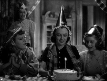 Movie still from “Stage Door” (1937), directed by Gregory La Cava – A group of people sitting around a cake; Medium shot, High angle