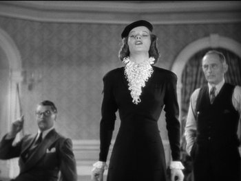 Movie still from “Stage Door” (1937), directed by Gregory La Cava – A woman in a black dress standing in front of two men; Medium shot, Low angle