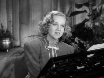 Movie still from “Stage Door” (1937), directed by Gregory La Cava – An old black and white photo of a woman playing the piano; Close Up shot, High angle