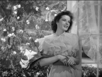 Movie still from “Stage Door” (1937), directed by Gregory La Cava – An old photo of a woman holding a bouquet of flowers; Medium shot, Low angle
