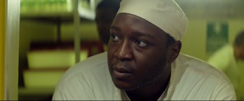 Movie still from “Starred Up” (2013), directed by David Mackenzie – A person wearing a white hat; Close Up shot, Low angle