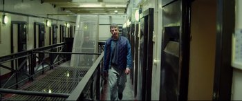 Movie still from “Starred Up” (2013), directed by David Mackenzie – A man walking down the stairs of a building; Medium shot, Low angle