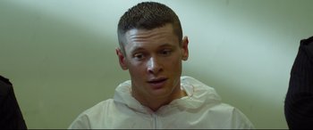 Movie still from “Starred Up” (2013), directed by David Mackenzie – A person wearing a white jacket; Close Up shot, High angle