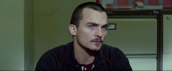 Movie still from “Starred Up” (2013), directed by David Mackenzie – A person with a mustache; Close Up shot, Over the shoulder angle