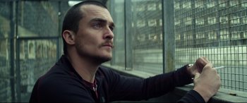 Movie still from “Starred Up” (2013), directed by David Mackenzie – A person looking out a window; Close Up shot, Low angle