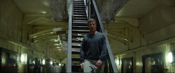 Movie still from “Starred Up” (2013), directed by David Mackenzie – A man standing in front of some stairs in a building; Wide shot, Low angle