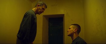 Movie still from “Starred Up” (2013), directed by David Mackenzie – Two men are facing each other in a dimly - lit room; Medium shot, Over the shoulder angle