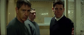 Movie still from “Starred Up” (2013), directed by David Mackenzie – A group of men standing next to each other in a room; Medium shot, Over the shoulder angle