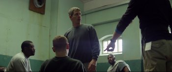 Movie still from “Starred Up” (2013), directed by David Mackenzie – A group of people in a room talking to each other; Medium shot, Over the shoulder angle