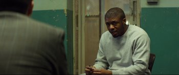 Movie still from “Starred Up” (2013), directed by David Mackenzie – A man sitting in front of another man in a room; Medium shot, Over the shoulder angle