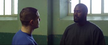 Movie still from “Starred Up” (2013), directed by David Mackenzie – Two men are facing each other in a room; Medium shot, Over the shoulder angle