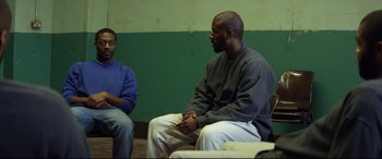 Movie still from “Starred Up” (2013), directed by David Mackenzie – Two men are sitting in a room talking to each other; Medium shot, Over the shoulder angle