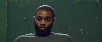 Movie still from “Starred Up” (2013), directed by David Mackenzie – A person with a beard; Close Up shot, Over the shoulder angle