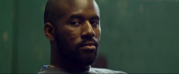 Movie still from “Starred Up” (2013), directed by David Mackenzie – A person with a beard; Close Up shot, Over the shoulder angle