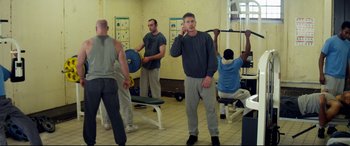 Movie still from “Starred Up” (2013), directed by David Mackenzie – A group of men standing in a room; Wide shot, High angle
