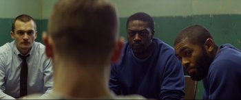 Movie still from “Starred Up” (2013), directed by David Mackenzie – A man sitting in front of a mirror looking at himself in the mirror; Close Up shot, Over the shoulder angle