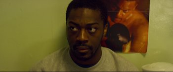 Movie still from “Starred Up” (2013), directed by David Mackenzie – A person looking at the camera; Close Up shot, High angle