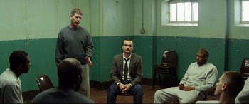 Movie still from “Starred Up” (2013), directed by David Mackenzie – Two men sitting in front of each other in a room; Wide shot, Over the shoulder angle