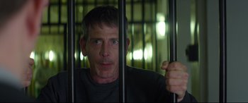 Movie still from “Starred Up” (2013), directed by David Mackenzie – A person behind bars in a jail cell; Close Up shot, Over the shoulder angle