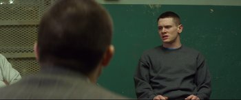 Movie still from “Starred Up” (2013), directed by David Mackenzie – A man sitting in front of a mirror talking to another man; Medium shot, Over the shoulder angle