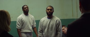 Movie still from “Starred Up” (2013), directed by David Mackenzie – A group of men standing next to each other in a room; Medium shot, Over the shoulder angle