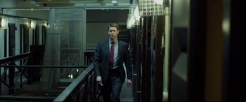 Movie still from “Starred Up” (2013), directed by David Mackenzie – A man in a suit and tie walking down stairs; Medium shot, Low angle