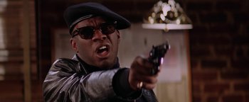 Movie still from “Starsky & Hutch” (2004), directed by Todd Phillips – A man holding a gun and wearing a hat; Close Up shot, Low angle