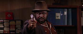 Movie still from “Starsky & Hutch” (2004), directed by Todd Phillips – A man holding a gun in his right hand and wearing a hat; Close Up shot, Low angle