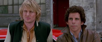 Movie still from “Starsky & Hutch” (2004), directed by Todd Phillips – Two men sitting next to each other in front of a red car; Close Up shot, Low angle