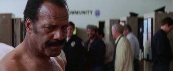 Movie still from “Starsky & Hutch” (2004), directed by Todd Phillips – A group of men standing in front of a community sign; Close Up shot, Low angle