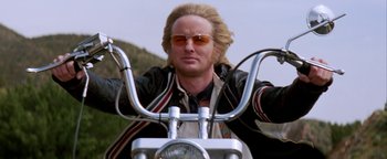 Movie still from “Starsky & Hutch” (2004), directed by Todd Phillips – A man with long blonde hair on a motorcycle; Close Up shot, Low angle