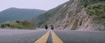 Movie still from “Starsky & Hutch” (2004), directed by Todd Phillips – Two people riding motorcycles down a mountain side road; Extreme Wide shot, Low angle