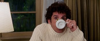 Movie still from “Starsky & Hutch” (2004), directed by Todd Phillips – A man in a sweater drinking from a mug; Medium shot, Low angle