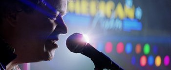 Movie still from “Starsky & Hutch” (2004), directed by Todd Phillips – A man is holding a microphone up to his mouth; Extreme Close Up shot, Low angle