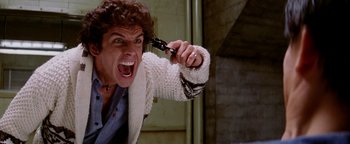 Movie still from “Starsky & Hutch” (2004), directed by Todd Phillips – A man is holding a pair of scissors in one hand and a knife in the other hand; Close Up shot, Overhead angle